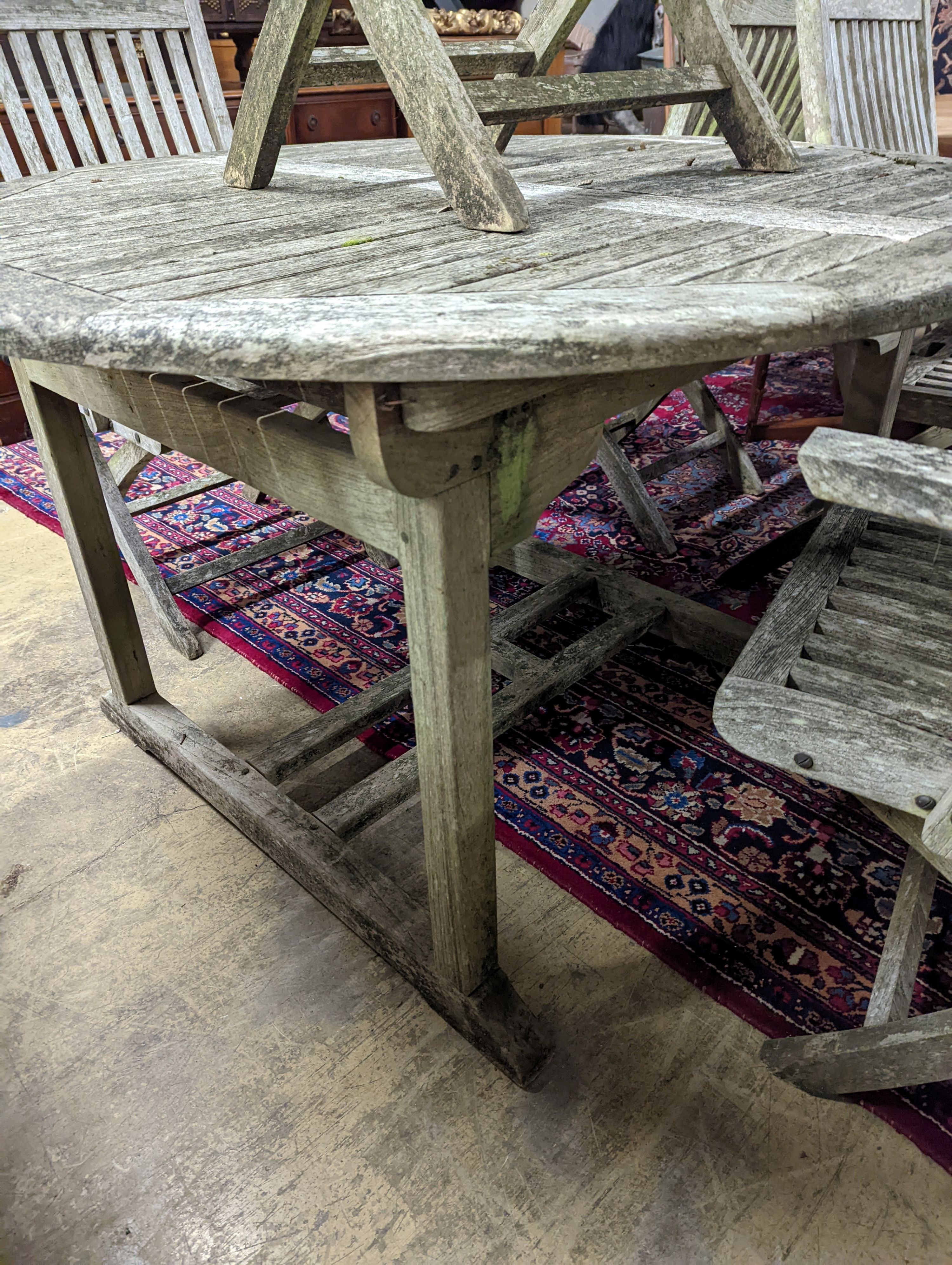 A weathered teak circular extending garden table, 120cm diameter, height 74cm together with five Lindsey teak folding garden elbow chairs